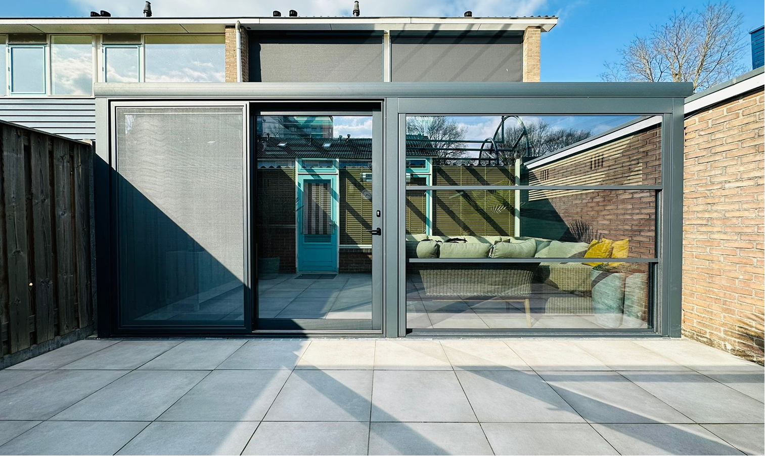 Aluminium veranda met glazen schuifwanden aan een moderne woning